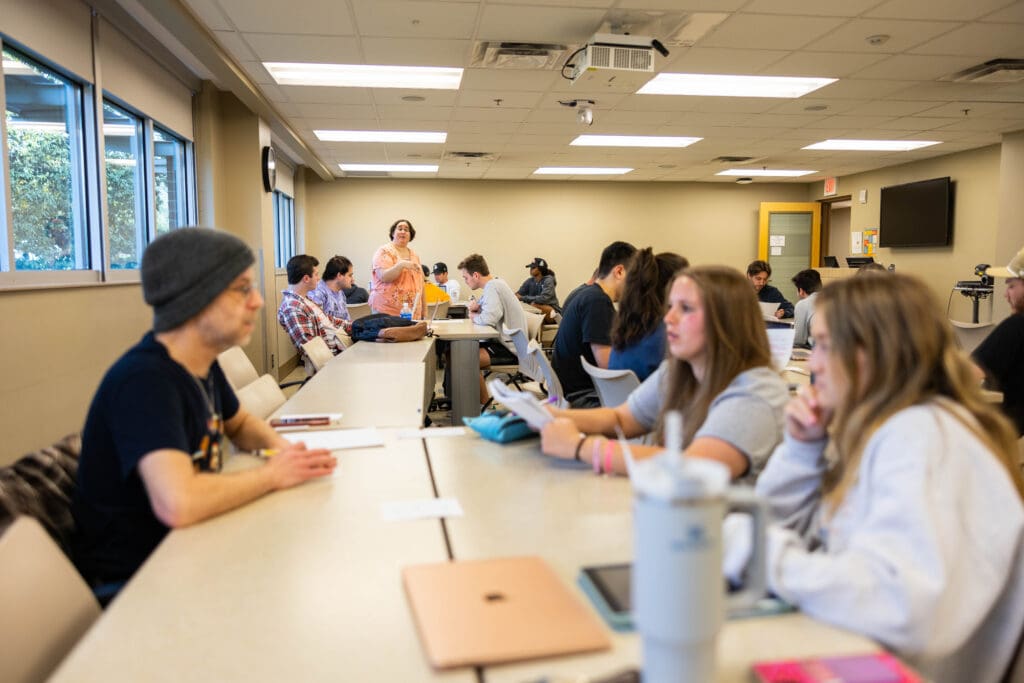 Students sit at a table in a Communications Studies class